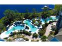 Aerial view of a luxury pool area with winding pools, palm trees, and lakeside views at 15695 Grove Resort Ave # 4438, Winter Garden, FL 34787