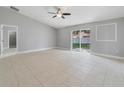 Spacious living room featuring neutral paint, ceiling fan and tile flooring with backyard views at 160 Conch Dr, Kissimmee, FL 34759