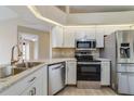 Well-equipped kitchen with stainless steel appliances, white cabinetry, and granite countertops at 2880 Trenton Ln, Deltona, FL 32738