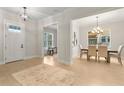 Welcoming foyer with light hardwood floors, a dining area, and a view of a home office through an open doorway at 3022 Peel Ave, Orlando, FL 32806