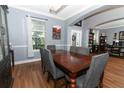 Open-concept dining room with hardwood floors, a wooden dining table, and gray chairs at 319 Morning View Dr, Winter Garden, FL 34787