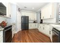 Spacious kitchen features white cabinetry, granite counters, and stainless refrigerator at 319 Morning View Dr, Winter Garden, FL 34787