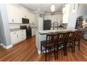 Bright kitchen features white cabinetry, granite counters, stainless appliances, and wood flooring at 319 Morning View Dr, Winter Garden, FL 34787