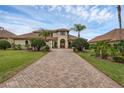 Expansive home featuring a tiled driveway, meticulously manicured landscaping, and mature palm trees at 4031 Bermuda Grove Pl, Longwood, FL 32779