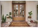 Elegant wood double doors welcome you with decorative plants and a 'Welcome' mat at 4031 Bermuda Grove Pl, Longwood, FL 32779