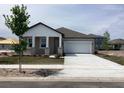 Traditional home with covered porch, stone pillar accents, attached garage and concrete driveway at 5733 Haystack Drive, St Cloud, FL 34771