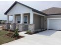Inviting front porch with stone pillar accents and white columns, adding architectural interest at 5733 Haystack Drive, St Cloud, FL 34771