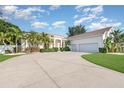 Spacious driveway leads to a three-car garage, complemented by tropical landscaping and a well-maintained lawn at 6121 Oxbow Bend Ln, Port Orange, FL 32128