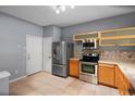 Functional kitchen featuring stainless steel appliances, light wood cabinetry, and tiled flooring for easy maintenance at 6360 Ranelagh Dr # 104, Orlando, FL 32835