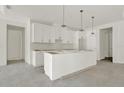 Bright kitchen showcasing an island, white cabinets, and modern pendant lighting at 9241 Eagles Perch Pl, Orlando, FL 32825