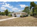 A single-story home showcasing a well-maintained exterior with green shrubbery along the side and a driveway at 1198 E Hancock Dr, Deltona, FL 32725