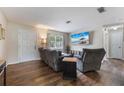 Comfortable living room with hardwood floors, a flat-screen TV, and a view of the front door and window at 1198 E Hancock Dr, Deltona, FL 32725