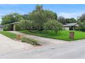 A well-maintained home showcasing a spacious driveway, mature tree, and neatly landscaped front yard at 1271 Old Mill Rd, Orlando, FL 32806