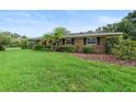 Charming brick home featuring a lush green lawn, mature landscaping, and classic architectural details at 1271 Old Mill Rd, Orlando, FL 32806