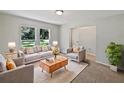 Bright living room features large windows, neutral tones, and comfortable seating arrangement with accent pillows at 13794 Sw 112Th St, Dunnellon, FL 34432