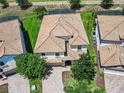An aerial view of a well-maintained home with a clay tile roof, beautiful landscaping, and a brick driveway at 1478 Moon Valley Dr, Davenport, FL 33896
