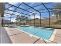Sparkling screened-in pool and spa surrounded by a brick patio with plenty of space for lounge chairs at 1478 Moon Valley Dr, Davenport, FL 33896