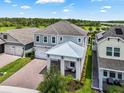 Aerial view of a beautifully landscaped two-story home highlighting the roof, lawn and brick paver driveway at 14955 Lebeau Loop, Winter Garden, FL 34787