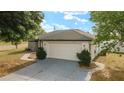 Two car garage with a paved driveway and well maintained landscaping at 16190 Sw 16Th Ct, Ocala, FL 34473