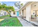 A well-maintained house with a blue door, lush green lawn, and a covered carport at 2417 Cedar Ave, Sanford, FL 32771