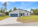 Beautiful single-story home with a modern gray exterior, blue accents, and a spacious front yard at 2506 Sw 158Th Lane Rd, Ocala, FL 34473