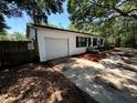 Shot of the home's exterior with a garage and minimal landscaping with fencing in the background at 25824 Shawnee St, Sorrento, FL 32776