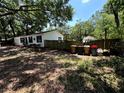 View of the side yard of the home with fencing and some large trashcans at 25824 Shawnee St, Sorrento, FL 32776