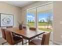 Dining room with large glass windows, a wood table, and view of the community's green space at 2871 Haze Rd, Clermont, FL 34714