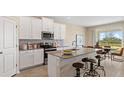 Modern kitchen with stainless steel appliances, an island with bar stools, and a dining area at 2871 Haze Rd, Clermont, FL 34714