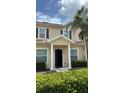 Charming tan two-story home with a covered entry, complemented by lush green shrubbery and a well-maintained lawn at 3229 Cupid Pl, Kissimmee, FL 34747