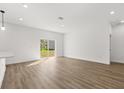Bright, open living room with wood-look flooring and sliding glass doors to the backyard at 441 Caraway Dr, Kissimmee, FL 34759