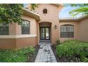 Elegant home featuring a beautiful entryway with stone pathway, lush landscaping, and a welcoming front door at 453 Sorrento Rd, Kissimmee, FL 34759