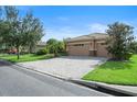 Charming home featuring a three-car garage and a spacious paver driveway, surrounded by manicured landscaping at 453 Sorrento Rd, Kissimmee, FL 34759