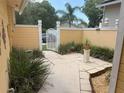 A gated courtyard is decorated with plants and flowers along the sides of the home at 561 Portland Cir, Apopka, FL 32703