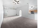 Spacious carpeted living room with neutral walls and an open layout to the kitchen area at 612 Doe Cove Pl, Apopka, FL 32703