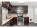 The gourmet kitchen features stainless steel appliances, dark cabinets, and stylish backsplash at 6245 Sleepy Hollow Dr, Orlando, FL 32810