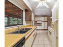 Bright kitchen with tile flooring, laminate countertops, and a large window overlooking the backyard at 7024 Harwick Dr, Orlando, FL 32818