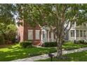 Charming two-story brick home with a well-manicured lawn and lovely green door at 704 Honeysuckle Ave, Kissimmee, FL 34747