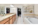 Spacious bathroom with granite counters, double sinks, a soaking tub, and glass enclosed shower at 707 Evening Sky Dr, Oviedo, FL 32765