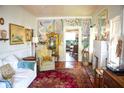 Eclectic living room featuring hardwood floors, fireplace, decorative mural, and view into the kitchen at 748 W Florence Ave, Deland, FL 32720