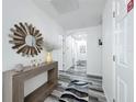 Bright entryway featuring wood-look flooring, modern console table and decorative mirror at 8518 La Isla Dr, Kissimmee, FL 34747