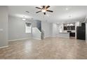 Open-concept living space featuring tile flooring, a ceiling fan, and stairs leading to the second floor at 10172 Storey Grove Way, Winter Garden, FL 34787