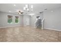 Bright living room with large windows, tile flooring, and stairs, and modern light fixture at 10172 Storey Grove Way, Winter Garden, FL 34787