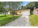 Lovely single-story home featuring a well-kept lawn and long driveway leading to an attached garage at 10849 William Tell Dr, Orlando, FL 32821