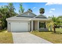 Charming single-story home with a well-manicured lawn, paved driveway, and attached garage at 1119 W 7Th St, Sanford, FL 32771