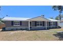Inviting home exterior showcasing a metal roof, neutral paint, and well-maintained landscaping at 11624 Ocklawaha Dr, Leesburg, FL 34788
