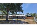 Charming home featuring a metal roof, neutral paint, and mature trees in a well-manicured front yard at 11624 Ocklawaha Dr, Leesburg, FL 34788