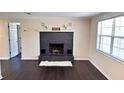 Cozy living room with a striking black brick fireplace and dark hardwood floors at 11624 Ocklawaha Dr, Leesburg, FL 34788