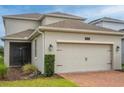 A beautiful suburban home featuring a two-car garage and a screened in porch at 11982 Travel Aly, Orlando, FL 32832