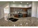 Well-appointed kitchen featuring stainless steel appliances, granite countertops, and dark wood cabinetry at 1208 Castleport Rd, Winter Garden, FL 34787